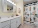 Bathroom with large mirror, white vanity, and shower with palm tree curtain at 5409 Caramella Dr, Orlando, FL 32829