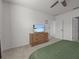 Bright bedroom with ceiling fan features dresser with TV at 5654 Winona Dr, St Cloud, FL 34771