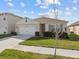 Well-maintained single-story home with a two-car garage and a green lawn at 5654 Winona Dr, St Cloud, FL 34771