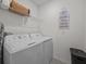 Bright laundry room with washer, dryer, and ample shelving at 5654 Winona Dr, St Cloud, FL 34771