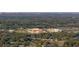 An aerial view of a community surrounded by trees, with glimpses of the local school and community buildings at 613 Bloom Ter, Davenport, FL 33837