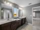 Bright bathroom featuring double vanities with dark cabinets, white countertops, and a large window at 613 Bloom Ter, Davenport, FL 33837