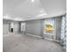 Spacious bedroom features tray ceiling, gray walls, carpet, and natural light from the two windows at 613 Bloom Ter, Davenport, FL 33837