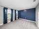 Bright bedroom with large windows, blue accent wall, and plush carpeting at 613 Bloom Ter, Davenport, FL 33837