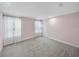 Bright bedroom with plush gray carpet, windows with white curtains, and a clean, neutral color scheme at 613 Bloom Ter, Davenport, FL 33837