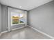 Bright bedroom with a large window overlooking a serene landscape and neutral grey paint at 613 Bloom Ter, Davenport, FL 33837