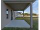 Covered patio looking out to an open lawn with a white picket fence, and neighboring homes beyond at 613 Bloom Ter, Davenport, FL 33837