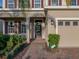 Inviting front entrance with brick walkway, tan walls, and dark red shutters on the windows at 613 Bloom Ter, Davenport, FL 33837