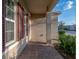 Side view of the front porch shows brickwork, tan walls, white trim, and colorful shutters at 613 Bloom Ter, Davenport, FL 33837