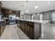 Spacious kitchen island with dark cabinets, white countertop, stainless steel sink, and pendant lighting at 613 Bloom Ter, Davenport, FL 33837