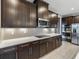 Close-up of a modern kitchen showcasing dark cabinets, quartz countertops, and stainless steel appliances at 613 Bloom Ter, Davenport, FL 33837