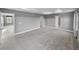 Large main bedroom with tray ceiling, carpet, and multiple doorways at 613 Bloom Ter, Davenport, FL 33837