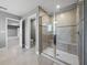 Modern tiled shower with glass enclosure and built-in seating in a bright, neutral-toned bathroom at 613 Bloom Ter, Davenport, FL 33837