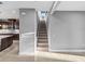 Carpeted staircase with gray walls and a view into the kitchen with dark cabinets and white countertops at 613 Bloom Ter, Davenport, FL 33837