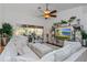 Bright living room with ceiling fan, sliding glass door, and comfortable white furniture at 6443 Axeitos Ter # 105, Orlando, FL 32835