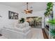 Bright living room with ceiling fan, sliding glass door, and comfortable white furniture at 6443 Axeitos Ter # 105, Orlando, FL 32835