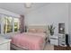 Bedroom with a large window, soft natural light, and light pink accents at 6443 Axeitos Ter # 105, Orlando, FL 32835