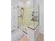 Modern glass-enclosed shower with built-in bench, shower caddy, and modern fixtures at 6443 Axeitos Ter # 105, Orlando, FL 32835