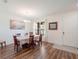 Bright dining room features hardwood floors, a chandelier, and a large window with natural light at 739 Annabell Ridge Rd, Minneola, FL 34715