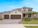 Charming two-story home features a three-car garage, stone accents, and a well-manicured front yard at 739 Annabell Ridge Rd, Minneola, FL 34715