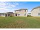 Large grassy backyard view of a two-story home, perfect for entertaining and recreation at 817 Sheen Cir, Haines City, FL 33844