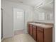 Bathroom featuring a double sink vanity with a large mirror and tiled floors at 817 Sheen Cir, Haines City, FL 33844