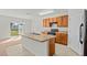 Bright kitchen with wood cabinets, a central island, and a sliding glass door leading to the backyard at 817 Sheen Cir, Haines City, FL 33844