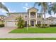 Two-story home showcasing manicured lawn and lush tropical landscaping, complemented by a two car garage at 10068 Chardonnay Dr, Orlando, FL 32832