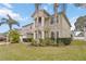 Two-story home showcasing manicured lawn and lush tropical landscaping, complemented by a two car garage at 10068 Chardonnay Dr, Orlando, FL 32832