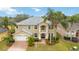Beautiful two-story home with mature palm trees, lush landscaping, and a brick driveway at 10068 Chardonnay Dr, Orlando, FL 32832