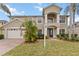 Two-story home showcasing manicured lawn and lush tropical landscaping, complemented by a two car garage at 10068 Chardonnay Dr, Orlando, FL 32832