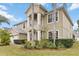Two-story home showcasing manicured lawn and lush tropical landscaping, complemented by a two car garage at 10068 Chardonnay Dr, Orlando, FL 32832