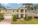 Charming two-story home featuring well-manicured landscaping and a welcoming brick pathway at 10068 Chardonnay Dr, Orlando, FL 32832
