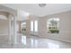 Bright living room with soaring ceilings, white columns, gorgeous tile floor and glass front door at 10068 Chardonnay Dr, Orlando, FL 32832