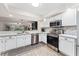 Modern kitchen with stainless steel appliances, white cabinets and views to living area at 1150 Carmel Cir # 503, Casselberry, FL 32707