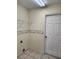 Small laundry room with tiled floor, simple white shelving, and decorative floral wallpaper border at 11618 Kipling Ct, Clermont, FL 34711