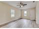 Spacious living room with modern ceiling fan, fresh paint, and stylish gray wood-look flooring at 11822 County Road 561, Clermont, FL 34711