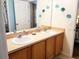 Bathroom featuring double sinks, vanity with storage, and decorative wall accents at 1217 Cypress Pointe Blvd, Davenport, FL 33896