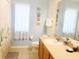 Bright bathroom featuring a large mirror, decorative wall art, and tiled flooring at 1217 Cypress Pointe Blvd, Davenport, FL 33896