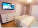 A well-lit bedroom with neutral walls features a sleek white dresser and a flat screen television at 1217 Cypress Pointe Blvd, Davenport, FL 33896