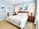 Bedroom with large queen bed, matching nightstands, and decoratively accented with beach and tropical art at 1217 Cypress Pointe Blvd, Davenport, FL 33896