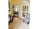 A welcoming foyer featuring neutral tile floors, decorative mirrors, and a view into the spacious living room at 1217 Cypress Pointe Blvd, Davenport, FL 33896