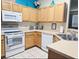 Well-lit kitchen featuring light wood cabinets, white appliances, and decoratively accented with pops of color at 1217 Cypress Pointe Blvd, Davenport, FL 33896