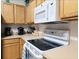 Modern kitchen with white appliances, light wood cabinets, and a neutral countertop space at 1217 Cypress Pointe Blvd, Davenport, FL 33896
