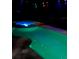 An in-ground pool glows at night with underwater lights, providing a tranquil and inviting atmosphere at 1217 Cypress Pointe Blvd, Davenport, FL 33896
