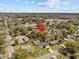 Overhead shot of a home nestled within a lush, green neighborhood under a blue sky with scattered clouds at 130 Mandrake St, Orlando, FL 32811
