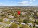 Aerial view of a residential area with many trees, homes, and a cityscape in the distant background at 130 Mandrake St, Orlando, FL 32811