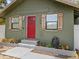 Up close view of the bungalow featuring a red door, the street number, and wood shutters at 130 Mandrake St, Orlando, FL 32811