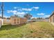 View of the backyard with a storage shed and a firepit with Adirondack chairs at 1340 Montoya Dr, Deltona, FL 32738