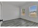 Sunlit bedroom with luxury vinyl plank flooring, two windows and white trim at 15657 Sw 37Th Cir, Ocala, FL 34473